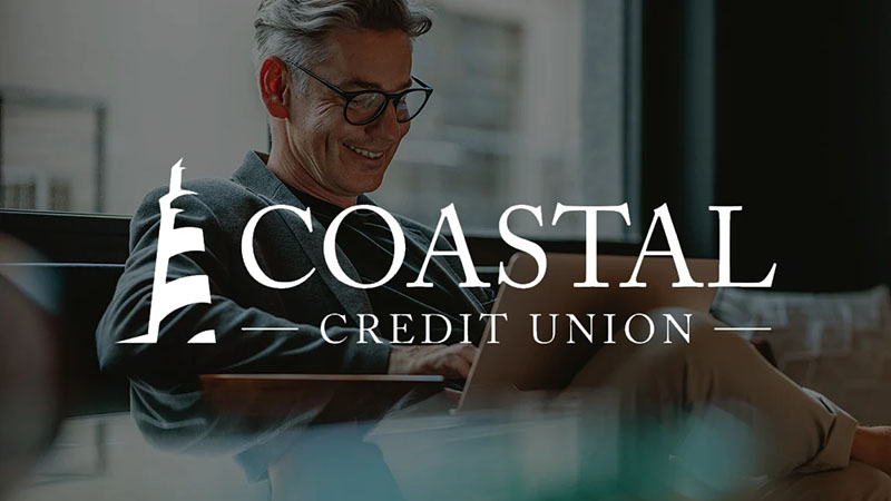 Coastal Credit Union logo overlaying imagery of a smiling man working on this laptop.