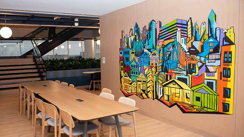 A vibrant painting of downtown Atlanta by Corey Barksdale in the Visa office