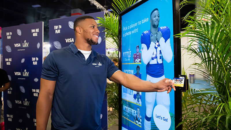 Saquon Barkley taps at the Visa Super Bowl experience. 