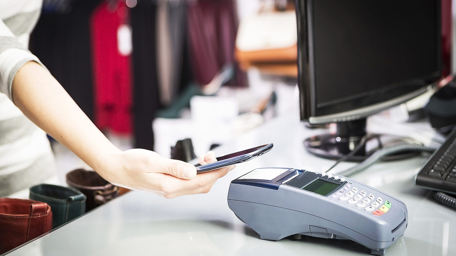 Woman using Apple Pay at checkout. Woman using Apple Pay at checkout.