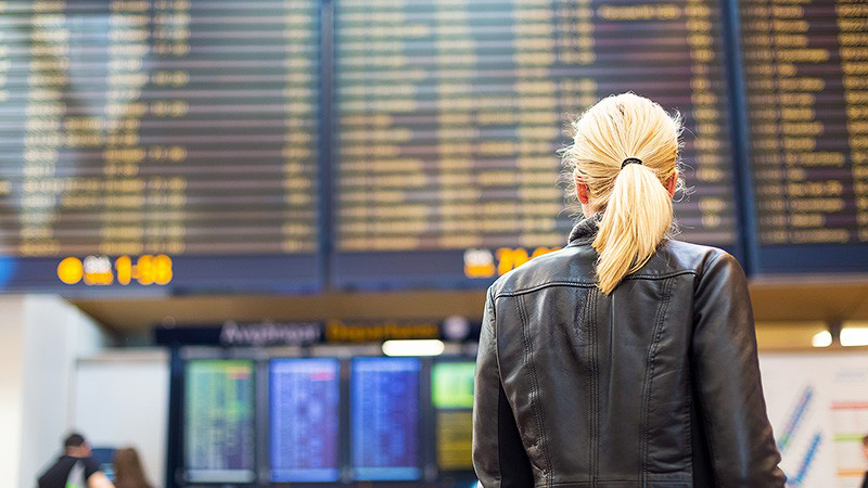 Woman looking at a travel schedule Woman looking at a travel schedule