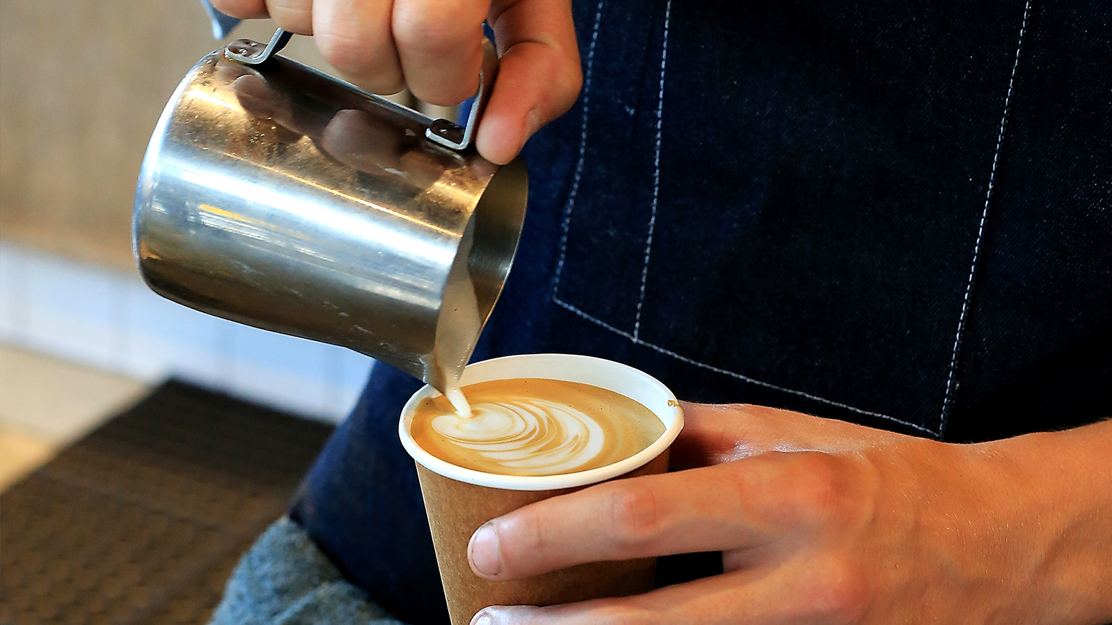 Barista adding steamed milk to expresso making a Cappuccino. Barista adding steamed milk to expresso making a Cappuccino.