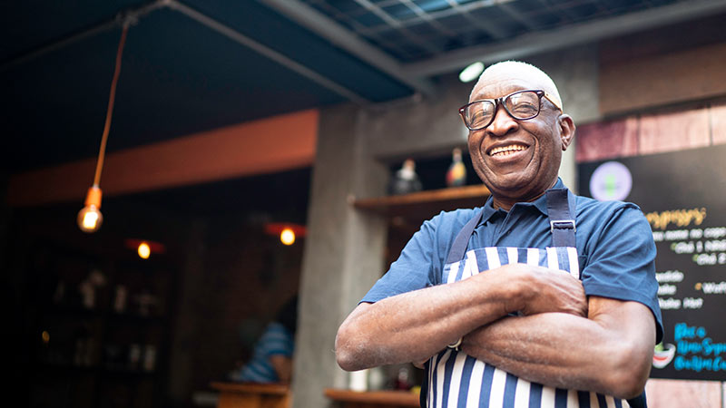 shopkeeper with arms crossed, smiling