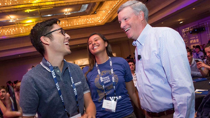 Visa CEO Al Kelly laughs while talking to two interns at the intern summit