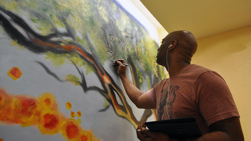 Artist Corey Barksdale paints in his studio