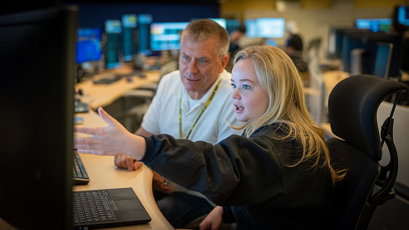 man and woman looking at computer screen together