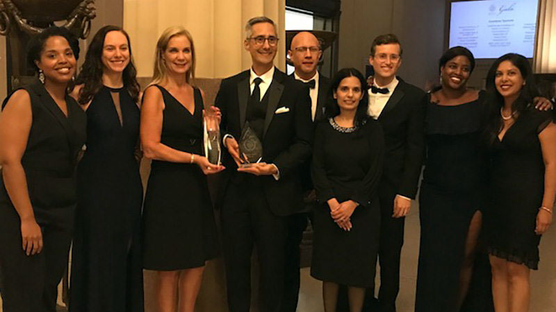 Nine members of Visa's legal team accept an award at a gala