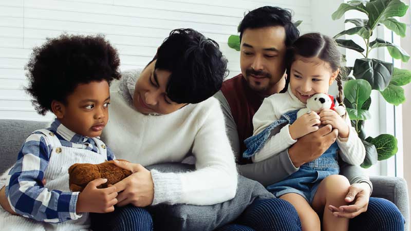 Family sits together on a couch