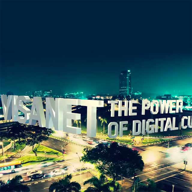 Overlook of a traffic intersection with words VisaNet The Power of Digital Currency edited over the photo.