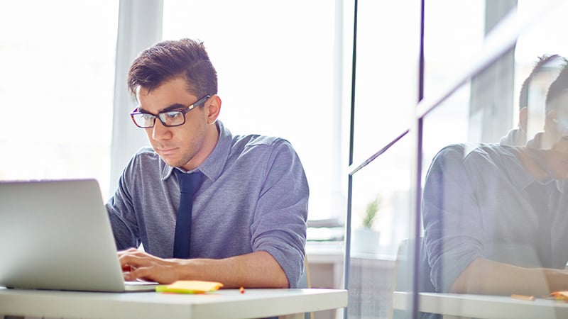 Seated man working with laptop
