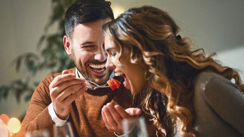 Man feeding a woman some food. Man feeding a woman some food.
