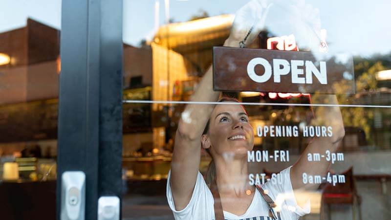 shes-next-ifundwomen-partnership-800x450 A young woman puts up an “open” sign in the window of a small business.