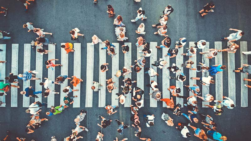 Aerial. People crowd on pedestrian crosswalk. Top view background. Toned image.