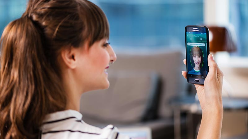 Woman using smart phone to calibrate facial recognition. Woman using smart phone to calibrate facial recognition.