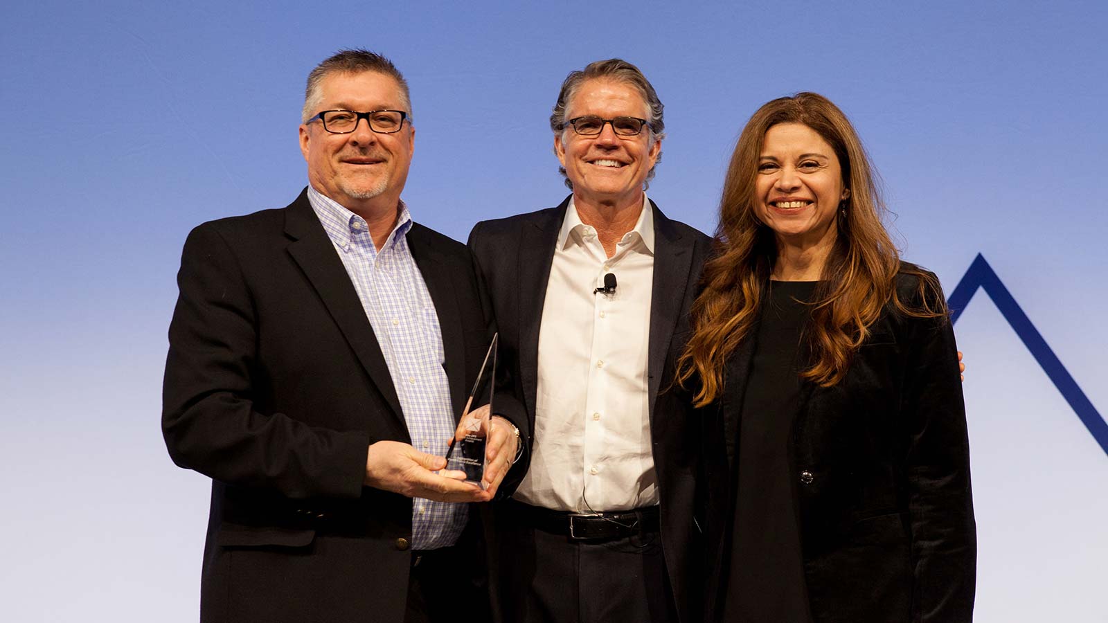 Man standing with male and female award winners.
