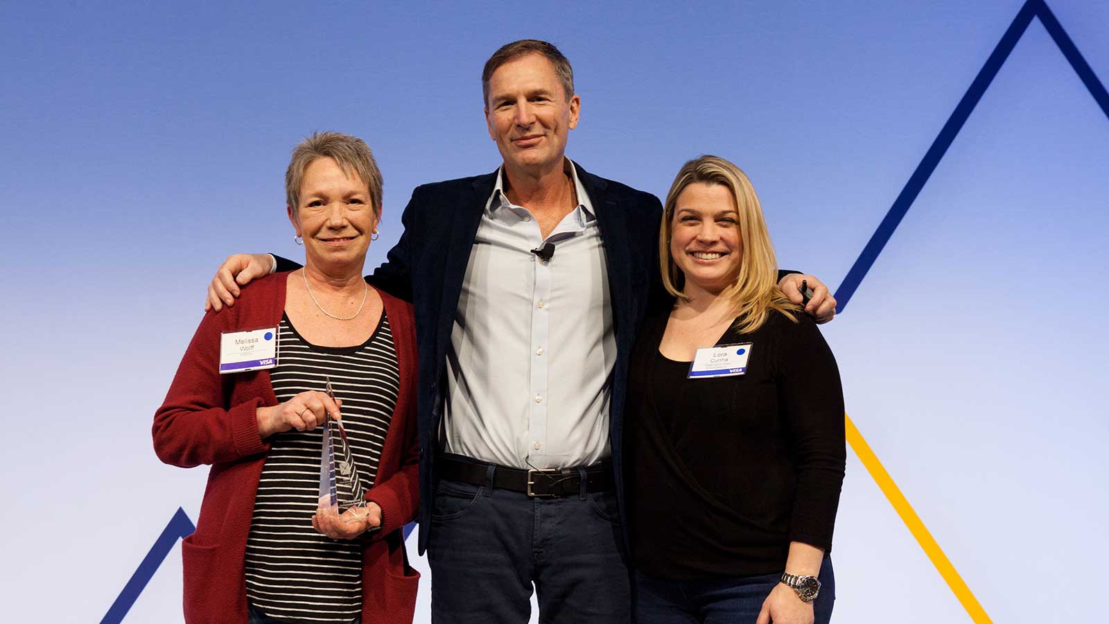 Man standing with two female award winners.