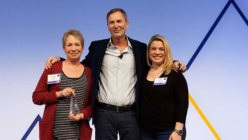 Man standing with two female award winners.