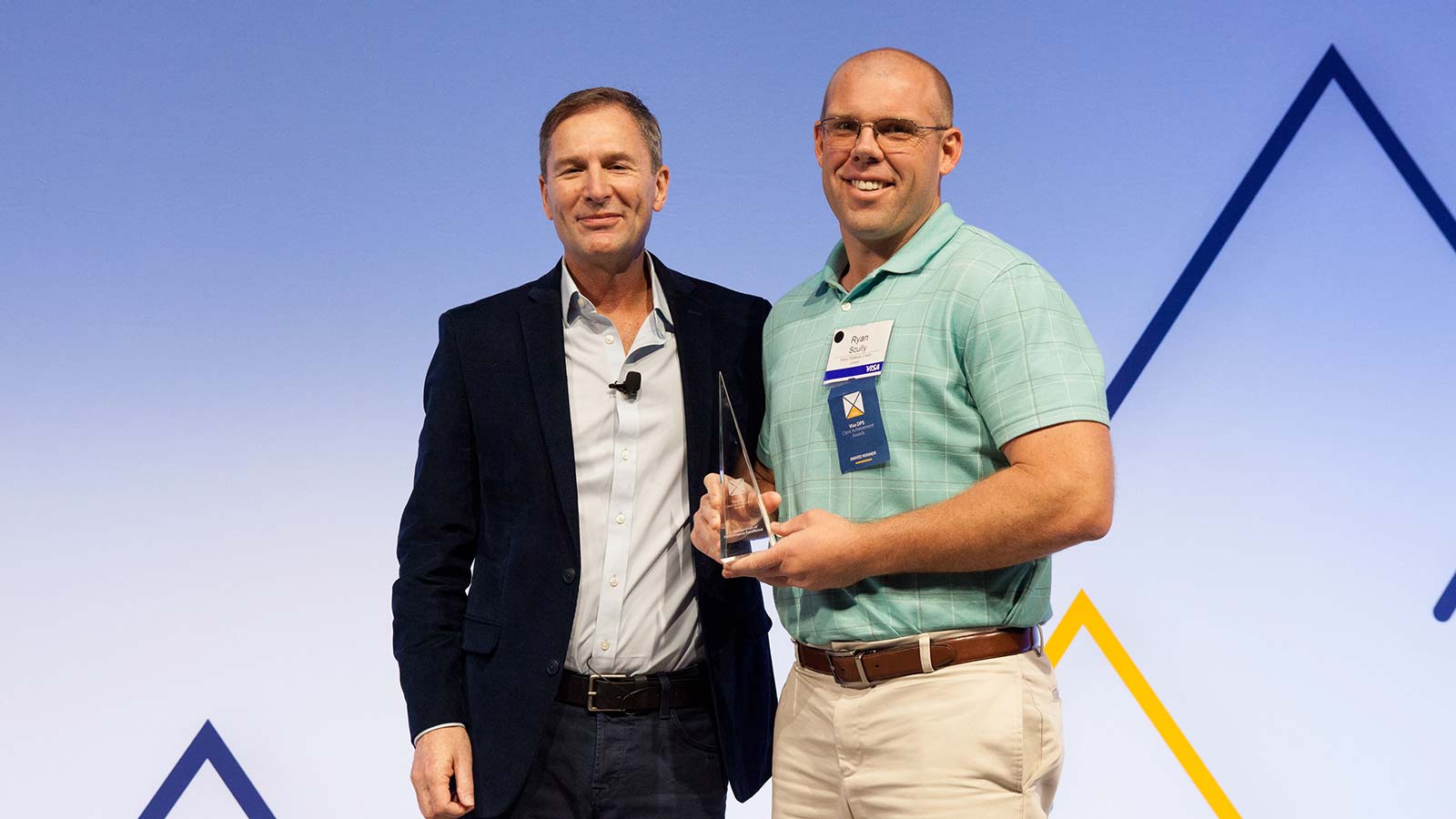 Man standing with a male award winner.