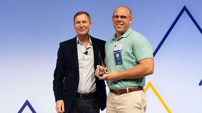 Man standing with a male award winner.
