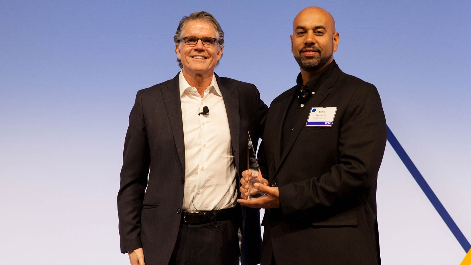 Man standing with male award winner. 