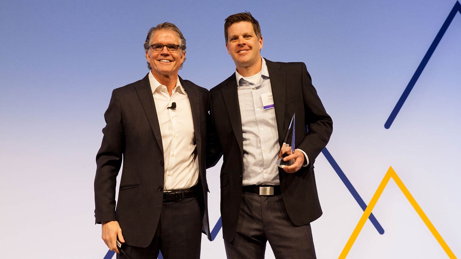 Man standing with male award winner. 