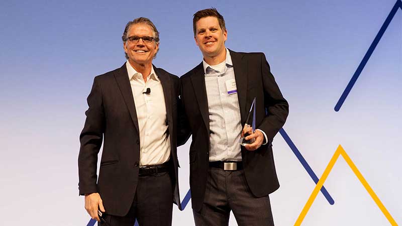 Man standing with male award winner.