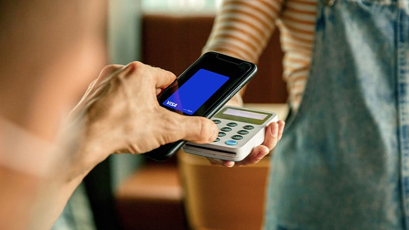 Using phone showing Visa-branded card to pay.