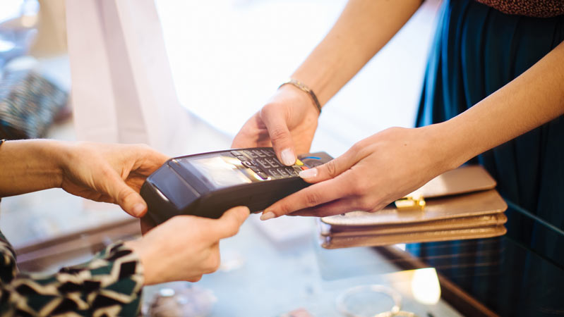 Female customer paying on credit card reader in boutique Female customer paying on credit card reader in boutique