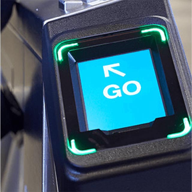 Close up of an OMNY card reader lit up with text GO and an arrow showing it’s OK to pass through the gate. 