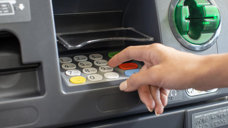 Customer using PIN pad to change card PIN at the ATM. Customer using PIN pad to change card PIN at the ATM.